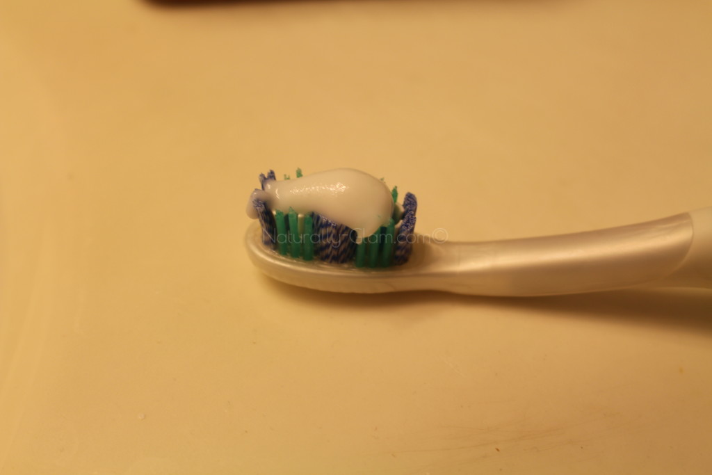 colgate optic white express white toothpaste on a tooth brush