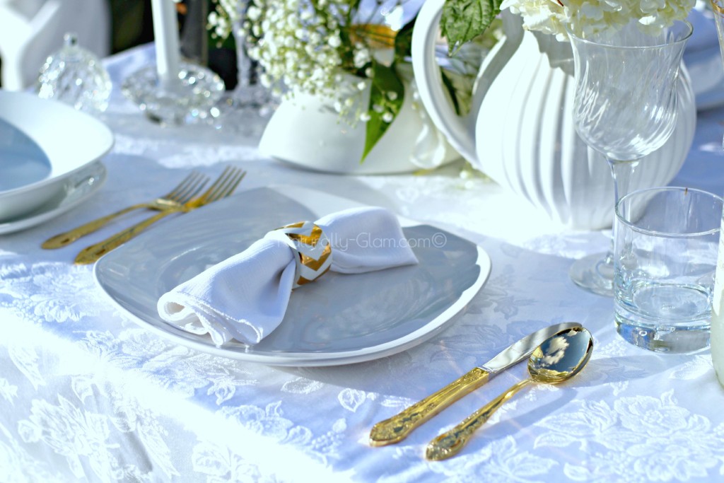 place setting with white plates, white napkin, and gold silverware
