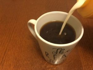 Pouring International Delight Simply Pure coffee creamer in coffee mug